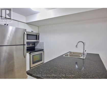 A kitchen with a granite countertop and stainless steel appliances.