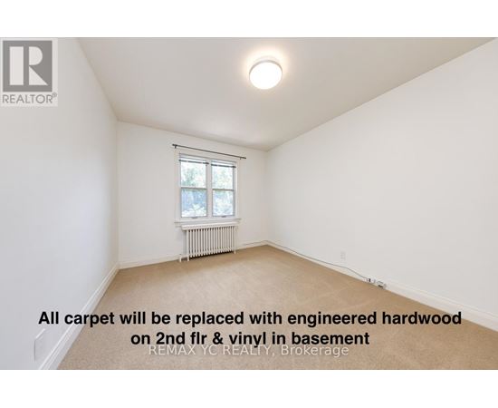 A room with a window and a radiator, with a note on the floor.