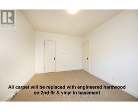 A room with a carpet floor and a door on the left.
