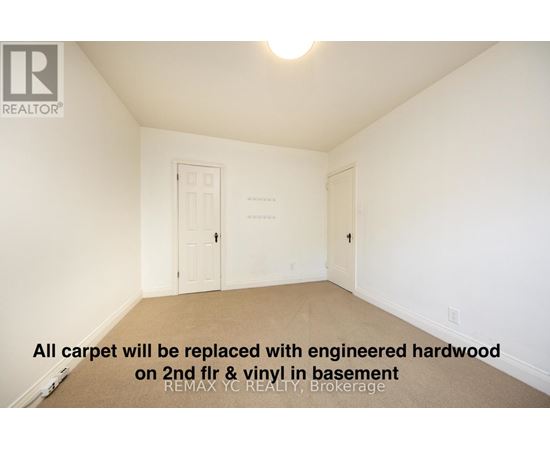 A room with a carpet floor and a door on the left.