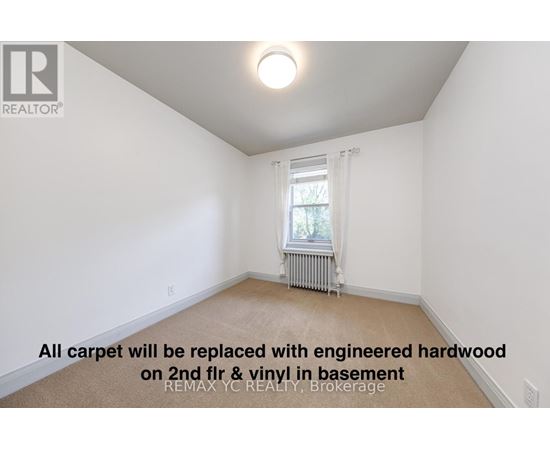 A room with a window and a radiator, with a note on the floor.
