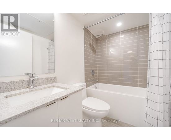 A white bathroom with a sink, toilet and bathtub.