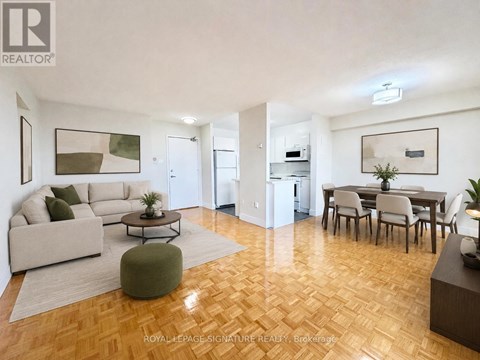 A living room with a couch, chairs, and a coffee table.