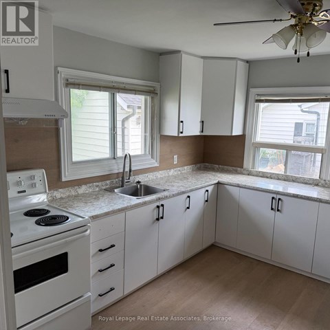 A kitchen with white cabinets and a stove top oven.