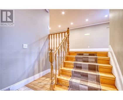 A staircase with a wooden banister and a checkered carpet.