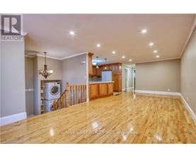 A spacious room with wooden flooring and a chandelier.