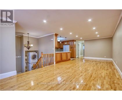 A spacious room with wooden flooring and a chandelier.