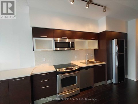 A kitchen with dark brown cabinets and stainless steel appliances.