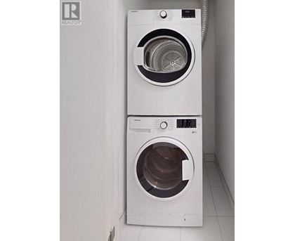 Two white front loading washing machines in a laundry room.