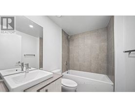 A bathroom with a toilet, sink, and bathtub.