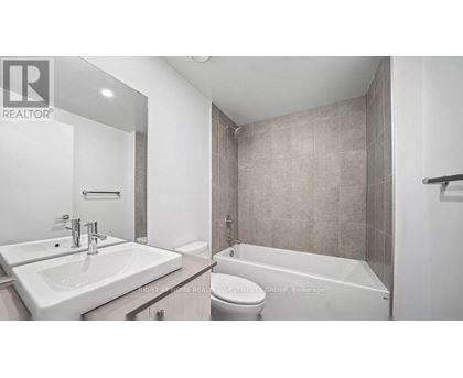 A bathroom with a toilet, sink, and bathtub.
