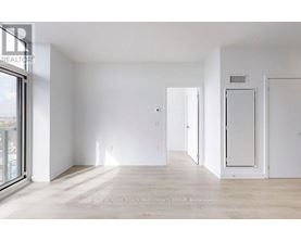 A spacious, empty room with white walls and a wooden floor.