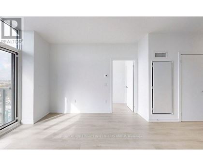 A spacious, empty room with white walls and a wooden floor.