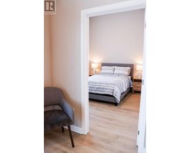 A bedroom with a bed and a chair.