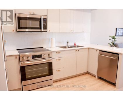 A modern kitchen with white cabinets and stainless steel appliances.
