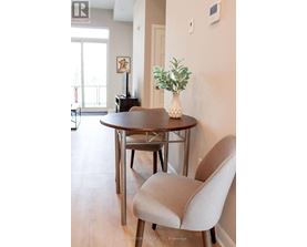 A dining room with a round table and a chair.