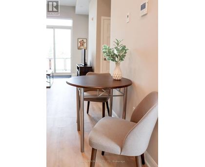 A dining room with a round table and a chair.