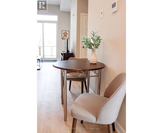 A dining room with a round table and a chair.