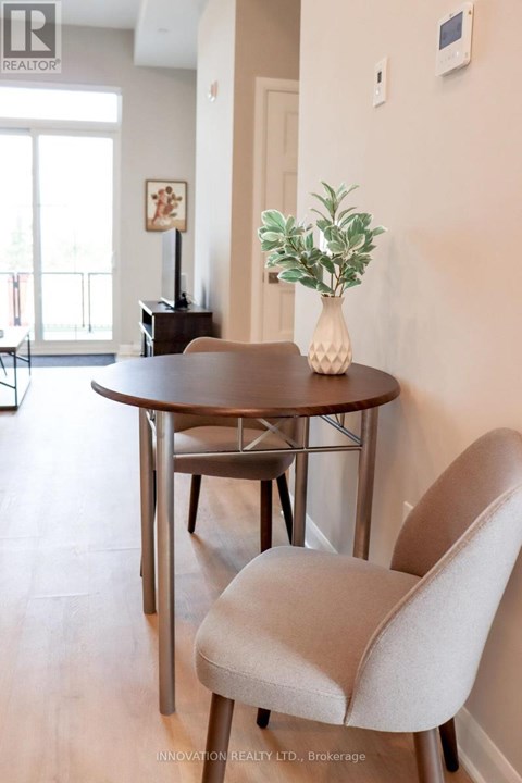 A dining room with a round table and a chair.