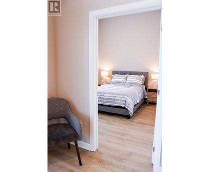 A bedroom with a bed and a chair.