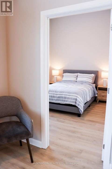 A bedroom with a bed and a chair.
