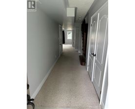 A hallway with white doors and carpeting.