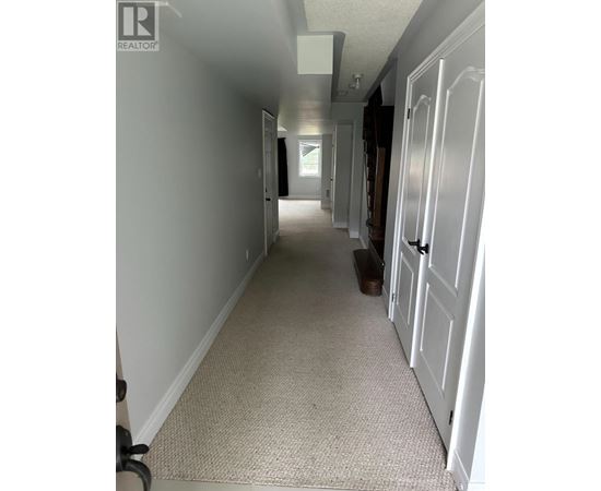 A hallway with white doors and carpeting.