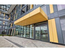 A modern building with a glass entrance and a yellow and grey facade.