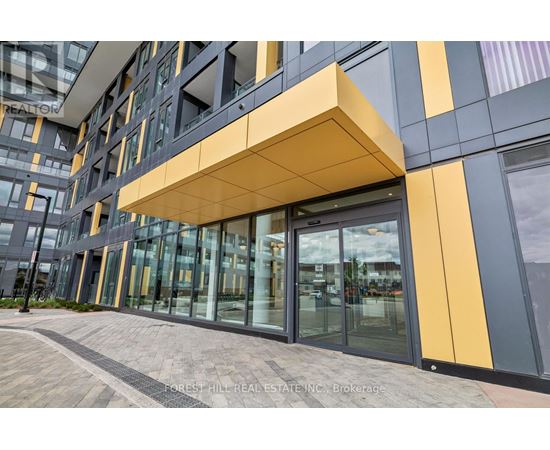 A modern building with a glass entrance and a yellow and grey facade.