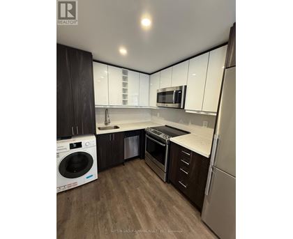 A modern kitchen with a washer and dryer built in.