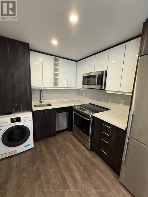 A modern kitchen with a washer and dryer built in.