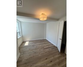 A room with wooden flooring and a light on the ceiling.