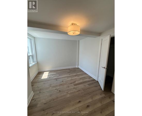 A room with wooden flooring and a light on the ceiling.
