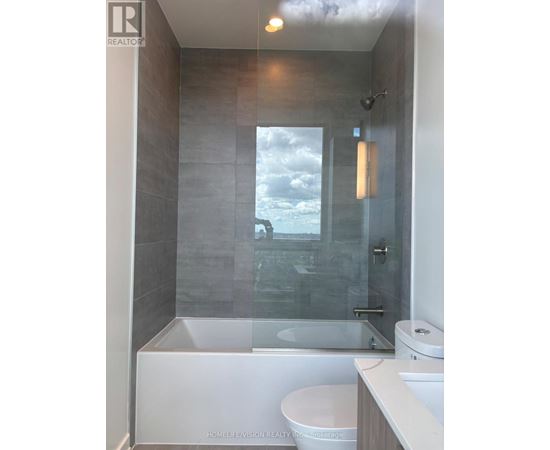 A modern bathroom with a glass shower door and a white toilet.