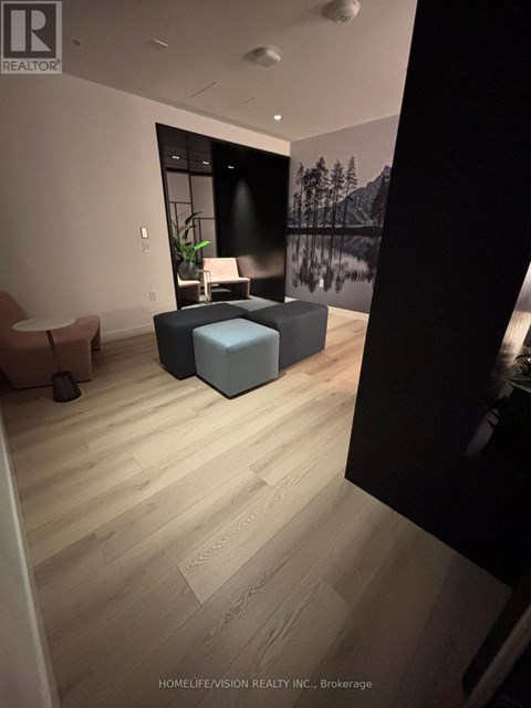 A living room with a grey sofa and a wooden floor.