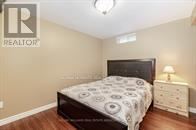 A bedroom with a bed, nightstand, and lamp.