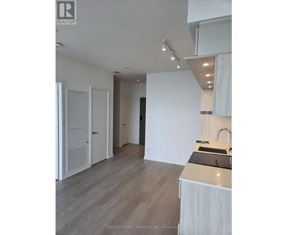 A modern kitchen with white cabinets and a wooden countertop.