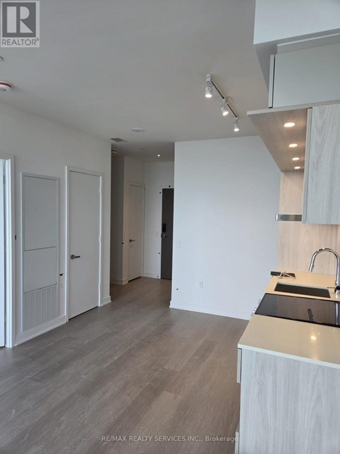 A modern kitchen with white cabinets and a wooden countertop.