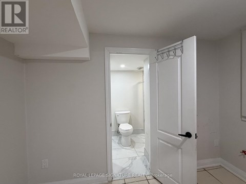 A white bathroom with a toilet and a door.