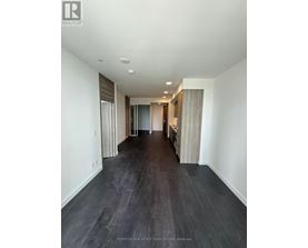A long hallway with dark wood floors and white walls.