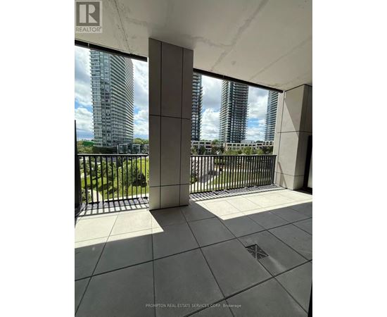 A balcony with a view of a cityscape and a building with the logo "REALTOR" on it.