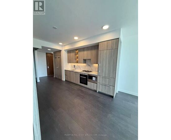 A modern kitchen with dark wood floors and a marble countertop.
