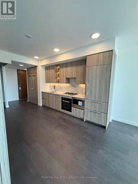A modern kitchen with dark wood floors and a marble countertop.