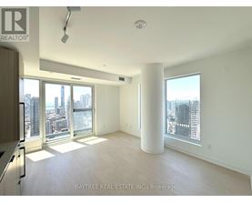 A spacious, empty room with a view of the city skyline.