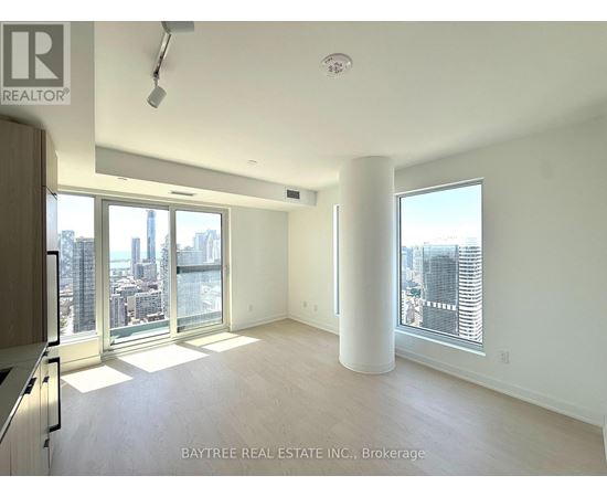 A spacious, empty room with a view of the city skyline.