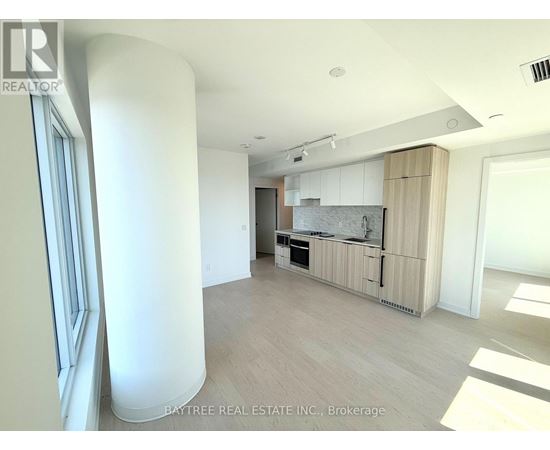 A spacious kitchen with white cabinets and a marble backsplash is seen in the image.