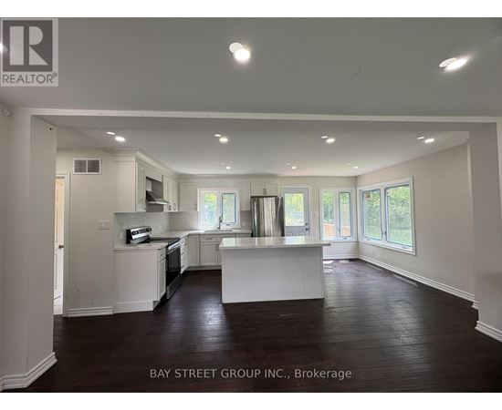 A spacious kitchen with white cabinets and a large island in the middle.