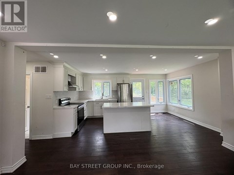 A spacious kitchen with white cabinets and a large island in the middle.