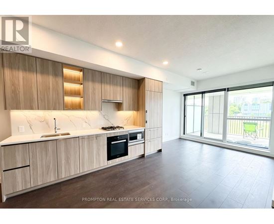 A kitchen with wooden cabinets and a countertop with a sink and stove.