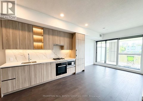 A kitchen with wooden cabinets and a countertop with a sink and stove.